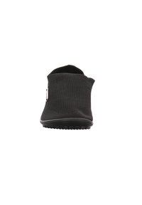 Schwarzer Slipper mit einer strukturierten Oberseite, weichem, flexiblem Design und einer Gummisohle mit kleinen Rillen für besseren Halt.