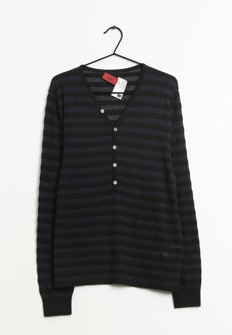 Czarny i ciemnogranatowy sweter w paski z długim rękawem, dekoltem w serek i pięcioma małymi okrągłymi guzikami, wiszący na czarnym wieszaku.