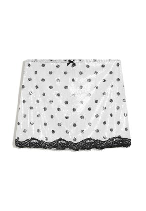 Bela čipkasta krila s črnimi pikami, črna čipkasta obroba na robu in majhna črna pentlja na pasu.