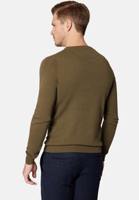 Oliwkowy sweter dzianinowy z okrągłym dekoltem, długimi rękawami oraz ściągaczami na mankietach i u dołu. Miękka tekstura i dopasowany krój.