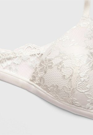 Lace bralette in light beige featuring floral patterns and a textured design. Soft satin band and adjustable straps.