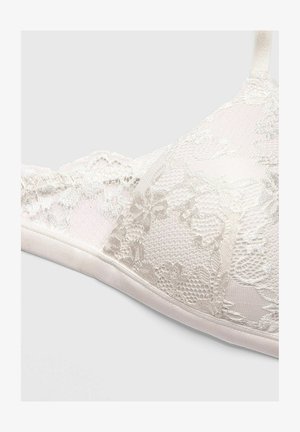 Lace bralette i lys beige med blomstermønstre og en struktureret design. Blød satinbånd og justerbare stropper.