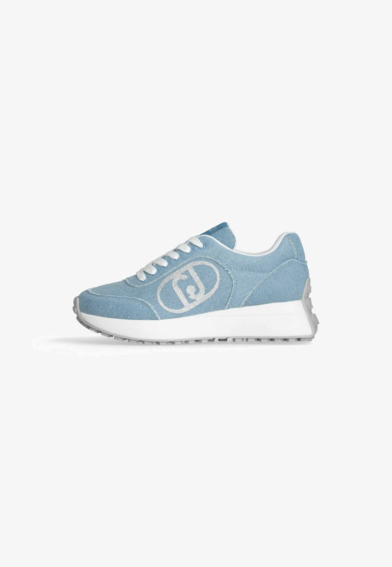 Sneaker en denim bleu clair avec des lacets blancs, semelle grise et un logo réfléchissant sur le côté. Dotée d'un design de semelle chunky et texturé.
