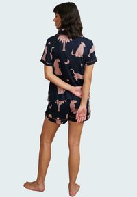 Navy Pyjama-Set mit lässiger Passform, kurzen Ärmeln und Shorts, die mit einem rosa Tier- und himmlischen Muster bedruckt sind, aus leichtem Stoff gefertigt.