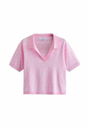 Light pink short-sleeve polo shirt with small white polka dots, V-neck collar, and cropped fit.