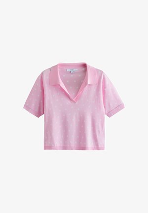 Light pink short-sleeve polo shirt with small white polka dots, V-neck collar, and cropped fit.
