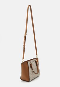 Borsa a tracolla in pelle marrone con un davanti in tessuto beige a fantasia, due manici per il trasporto, tracolla regolabile e dettagli in hardware dorato.