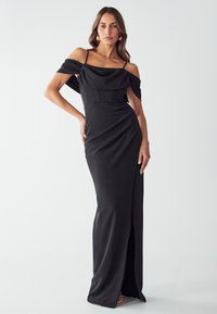 Vestito nero senza spalline con corpino drappeggiato, vita aderente, gonna lunga fino al pavimento e spacco alto sul davanti, realizzato in tessuto morbido.