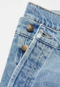 Ceinture de pantalon en jean bleu clair avec un bouton en métal portant l'inscription "DENIM" et une boutonnière partiellement ouverte.