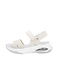 Lekki, beżowy sandał z siateczkowym wierzchem, regulowanymi paskami, miękką wkładką oraz przezroczystym akcentem poduszki powietrznej w pięcie.