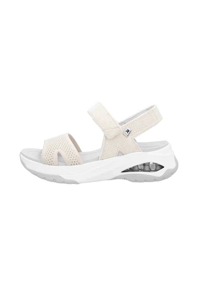 Lekki, beżowy sandał z siateczkowym wierzchem, regulowanymi paskami, miękką wkładką oraz przezroczystym akcentem poduszki powietrznej w pięcie.