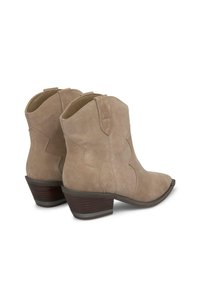 Beżowe zamszowe botki za kostkę z ostrym czubkiem i niewielkim obcasem, z przeszyciami i głębokim wcięciem przy kostce, co nadaje im zachodni styl.