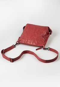 Rote Lederhandtasche mit glatter Textur, gefaltetem Design, Oberreißverschluss, verstellbarem Tragegurt und schwarzen Metallakzenten.