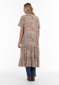 Robe longue et fluide avec un motif cachemire, comportant des manches courtes, une jupe à étages et une palette de couleurs dans des tons bruns, violets et crème subtils.