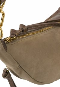 Borsa in suede marrone con un design curvo, accessori in oro e chiusura zip superiore. Presenta materiale testurizzato e dettagli di cucitura.