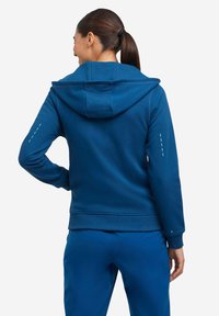 Felpa blu con cappuccio, caratterizzata da una finitura testurizzata, polsini a coste e un accento di design sottile sul maniche sinistra.