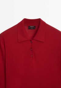 Rode wollen gebreide polo met lange mouwen, kraag en drie knopen op de sluiting, gemarkeerd Massimo Dutti, gemaakt in China.