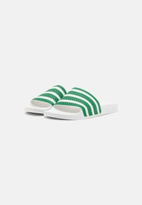 Zöld és fehér slip-on szandál három zöld vízszintes csíkkal, texturált felsőrésszel, nyitott orral és lapos, párnázott fehér talppal.