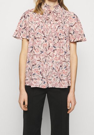 Blomsterbluse i lys pink med en samlet halsudskæring, korte ærmer og indviklede blomstermønstre i mørkere pink og navy.