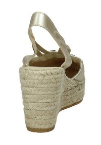 Sandali espadrilles a zeppa in oro metallico con tacco in juta intrecciata, cinturino alla caviglia regolabile e soletta imbottita. Superficie testurizzata che migliora la presa.