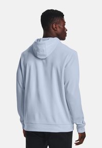 Hoodie bleu clair en tissu doux, avec une capuche à cordon, des manches longues et une coupe décontractée. Design simple sans motifs ni accents.