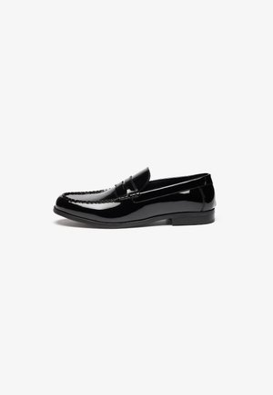Black patent leather loafer with a rounded toe, decorative stitching, and a low rubber heel. Smooth texture and sleek design.