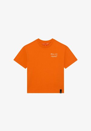 Fel oranje T-shirt met korte mouwen en een ronde hals met witte tekst "Reiss 1971 McLaren Formula 1 Team" op de linkerborst en een klein zwart labeltje aan de zoom.