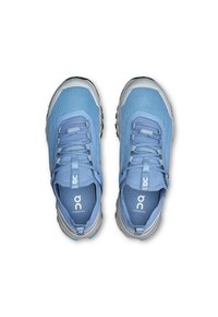 Light blue athletic shoes with mesh upper, rubber sole, and grey accents. Features lacing system and logo on the tongue.