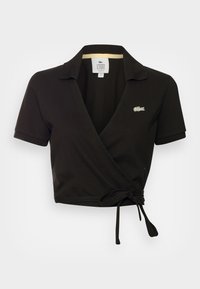 Czarna krótka koszulka polo z krótkimi rękawami, dekoltem w serek i wiązanym pasem. Wyhaftowane logo Lacoste na lewej piersi.