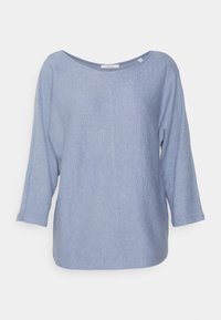 Ljusblå oversized tröja i texturerad tyg; har en bred halsringning och ärm i trekvartslängd.