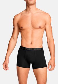 Schwarze Boxershorts aus Baumwolle mit einem elastischen Bund mit Markenschriftzug; figurbetonter Schnitt, glatte Textur, mittlere Oberschenkellänge, ohne zusätzliche Muster.