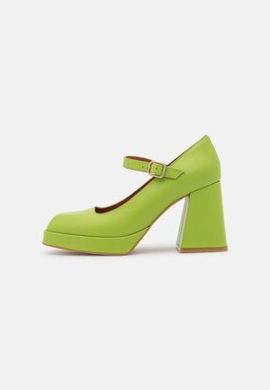 Grøn Mary Jane-stil lukkede sko med en chunky blokhæl, en platformsål og en spænde strop over foden.
