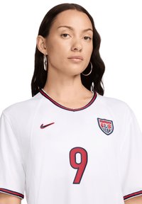 Maglietta da calcio Nike bianca con rifiniture rosse e blu, colletto rotondo e logo US Shield ricamato con il numero 9 in rosso.