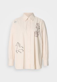 Ανοιχτό μπεζ πουκάμισο με κατακόρυφες ρίγες, διακοσμημένο με κεντημένες σχέσεις μονόκερου και φυτών στο μπροστινό μέρος. Μακριά μανίκια με λεπτομέρειες στους καρπούς.
