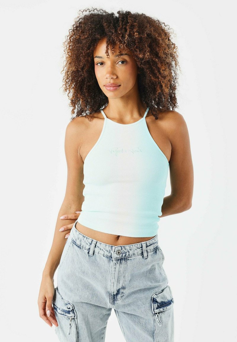 Un crop top a coste di colore blu chiaro con design a collo halter e un piccolo logo ricamato, abbinato a pantaloni cargo in denim chiaro.