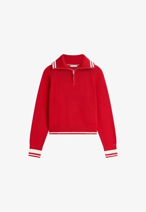 Czerwony sweter z dzianiny z długim rękawem, z suwakiem do ćwiartki długości, prążkowanym kołnierzem i dołem oraz białymi podwójnymi paskami na kołnierzu i mankietach.