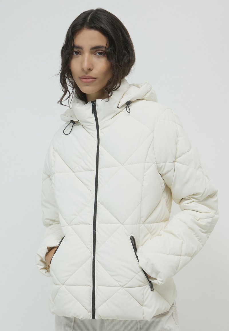 Weiß gesteppte Pufferjacke mit Kapuze, ausgestattet mit einem Frontreißverschluss und seitlichen Taschen, die in Schwarz eingefasst sind. Weiches Material mit glatter Oberfläche.