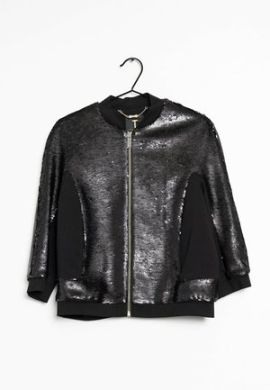 Veste bombardier noire avec un devant en sequins et un dos en tissu noir, dotée d'une fermeture éclair et d'un col rond. Surface texturée et coupe oversize.