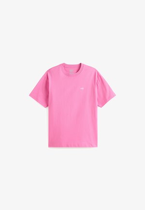 Camiseta de algodón rosa con mangas cortas y cuello redondo. Presenta un pequeño logo blanco en el lado izquierdo del pecho. Textura lisa, diseño casual.