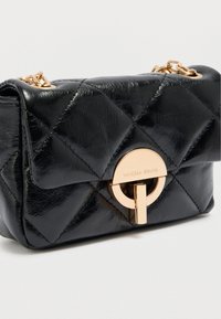 Μαύρη καπιτονέ δερμάτινη τσάντα χειρός με χρυσό στρογγυλό κούμπωμα. Διαθέτει ιμάντα αλυσίδα και λεία υφή με πιο γυαλιστερό φινίρισμα.