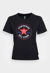 Camiseta de algodón negra con un gráfico circular que presenta una estrella roja, el texto "Converse" y "Chuck Taylor" en acentos blancos y azules. Mangas cortas.