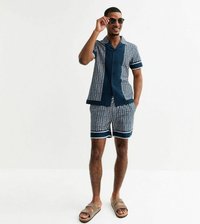 Chemise à manches courtes marine et shorts assortis avec un motif géométrique, des accents blancs et deux poches latérales. Porté avec des sandales brunes.