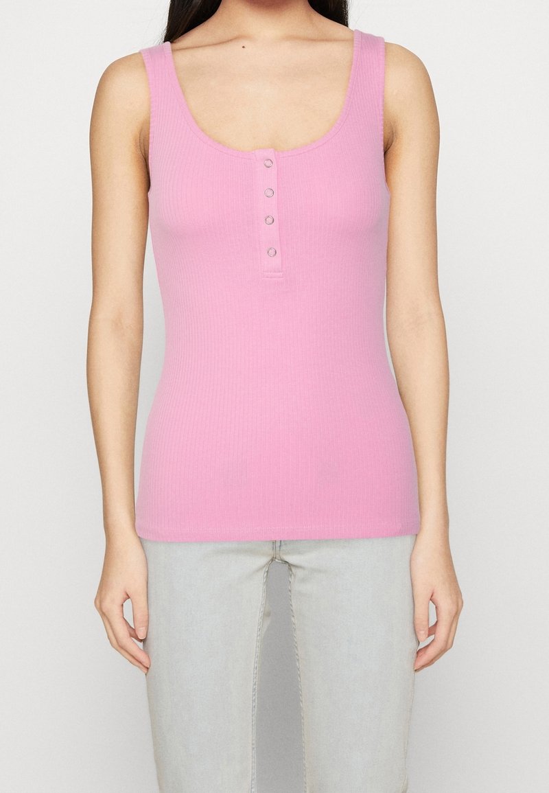 Rosa ribbat tanktopp med rund halsringning, med en framknäppning och breda axelband, tillverkad av ett mjukt, stretchigt material.