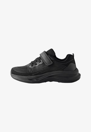 Czarny sportowy sneaker z siateczkową cholewką, z przodu sznurowany i z pojedynczym regulowanym paskiem na rzep nad sznurowadłami, widziany z boku.