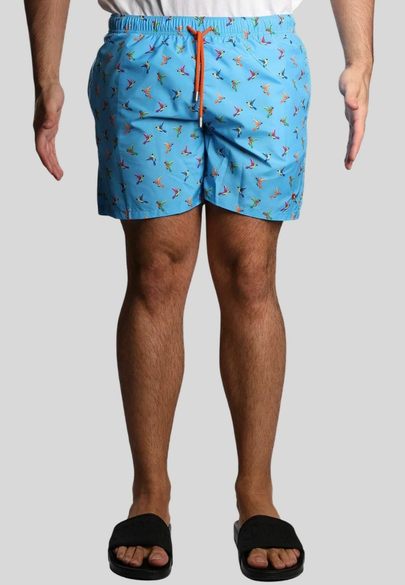Shorts da bagno azzurri chiari con un motivo di uccelli colorati, vita elasticizzata e un laccetto arancione. Indossati con sandali neri.