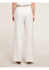 Szerokie spodnie w kolorze białym, wykonane z lekkiego materiału. Charakteryzują się wysokim stanem i gładką fakturą, z subtelnymi szwami wzdłuż nogawki.