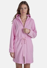 Rosa fleecemorgonrock med dragkedja, huva och dragsko i midjan. Har sidofickor och långa ärmar med manschetter. Mjuk textur och midilång design.