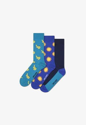 Three pairs of cotton socks: teal with banana pattern, blue with sun pattern, and dark blue. Each has contrasting cuffs and toe colors.
