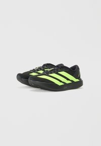 Zwarte sportieve schoenen met neon groene strepen, synthetische bovenkant, ronde neus en een gevoerde zool voor comfort en ondersteuning.