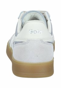 Weißer Sneaker mit grauen Wildlederakzenten und einem strukturierten Rückenteil, ausgestattet mit einer hellblauen Innenauskleidung und dem eingeprägten "Gola"-Logo an der Ferse.
